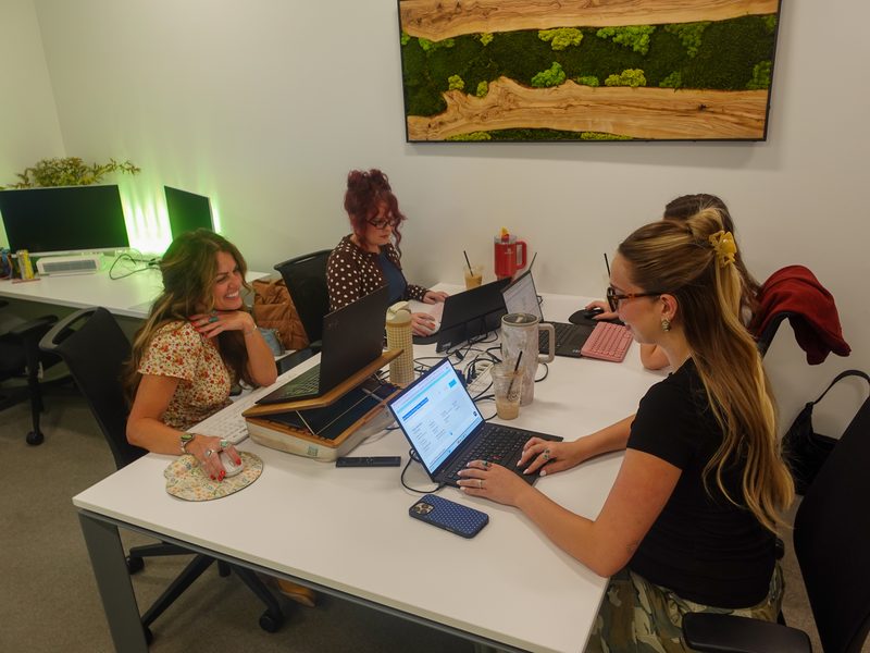 Brokers Alliance team members working together at a shared desk in the Fountain Hills office